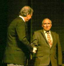 Grady Jim Robinson as Bill Clinton shakes hands with Al Gore, played by Rusty Garrett.